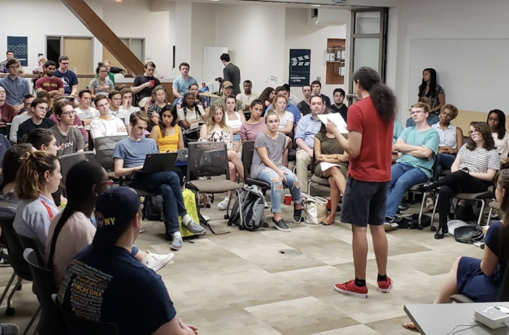 Young man speaking to a group in a college setting