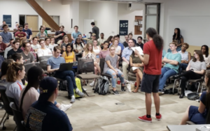 Young man speaking to a group in a college setting